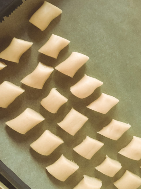 Weihnachtsplätzchen backen: in Stücke teilen und auf dem Backblech verteilen